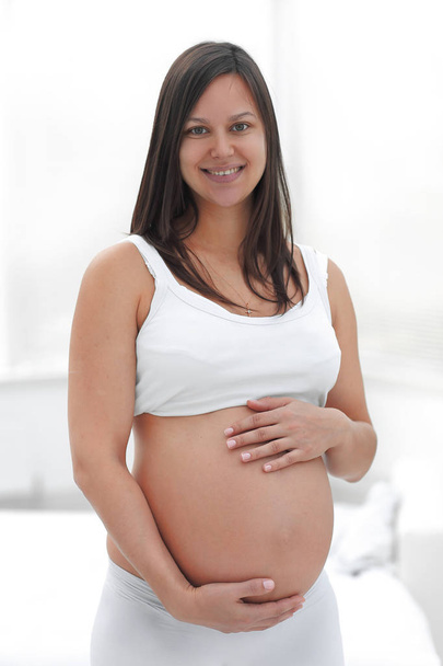 portrait of young pregnant woman on a light background. - Fotó, kép