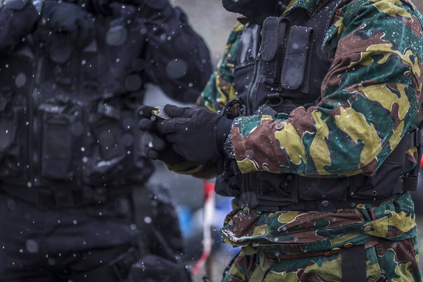Sotilaat harjoittelevat ampumista aseella. Joukko sotilaita harjoittelee kylmällä lumisella säällä. täysin varustettu laitteet ja naamiointi vaatteet mutainen ja likainen sää
. - Valokuva, kuva