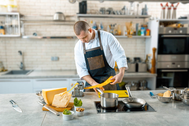 Шеф-повар делает тонкое тесто со специальной машиной, тонированное изображение
 - Фото, изображение