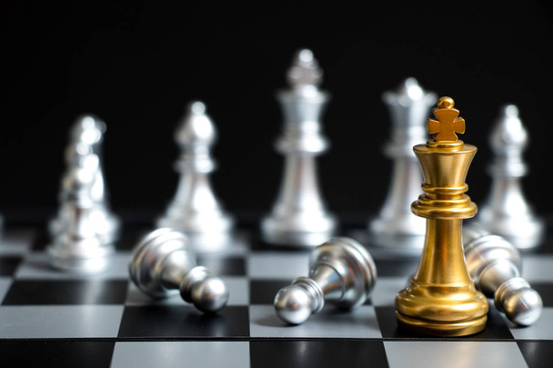 Goldkönig im Schachspiel Gesicht mit dem anderen Silberteam auf schwarzem Hintergrund (Konzept für Unternehmensstrategie, Geschäftssieg oder Entscheidung)) - Foto, Bild