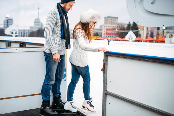 アクティブな冬のレジャー スケート リンクでスケートをする準備をしてカップルが大好き - 写真・画像