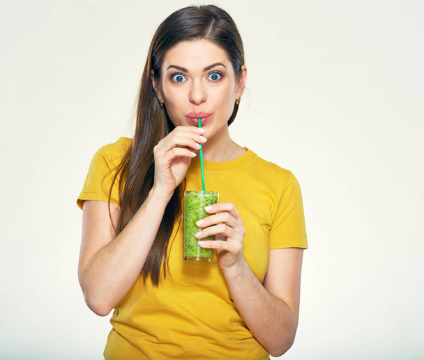 Young woman drinking green smoothie juice and looking at camera  - Photo, image
