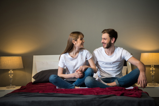 Mutlu genç çift elele birbirlerinin yatak modern tasarımı ile - Fotoğraf, Görsel