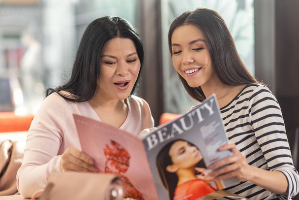 Delighted positive women reading a magazine - Foto, Bild