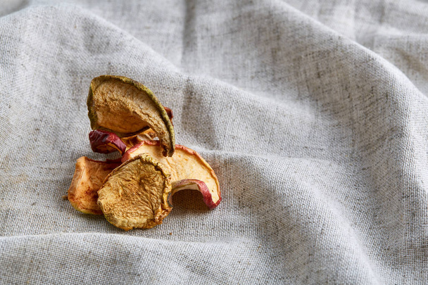 Top view close-up picture of dried apples on light cotton tablecloth, selective focus. - Fotó, kép