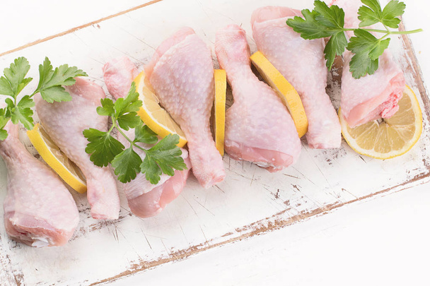Raw chicken legs on white wooden cutting board. Top view. Healthy eating concept - 写真・画像