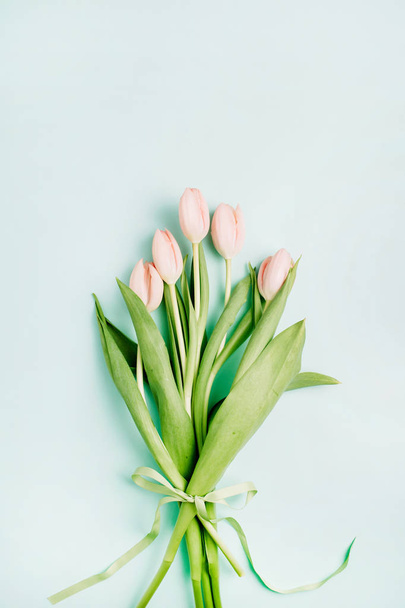 Vaaleanpunaiset tulppaanit kukkakimppu sinisellä taustalla. Litteä, ylhäältä päin. Minimaalinen kevät kukka käsite
. - Valokuva, kuva