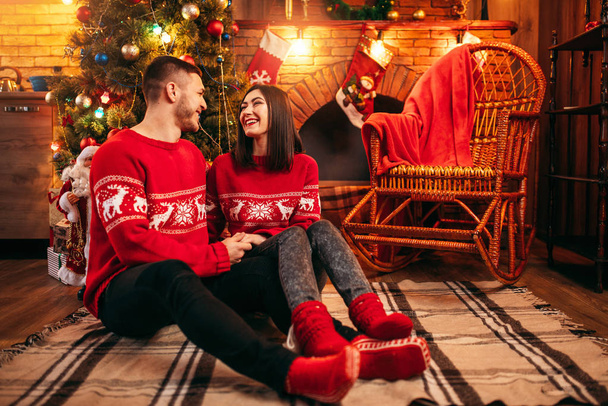 Ευτυχισμένη αγάπη ζευγάρι ξαπλωμένο στο πάτωμα, γιορτάζει διακοπές Χριστουγέννων μαζί στο σπίτι  - Φωτογραφία, εικόνα