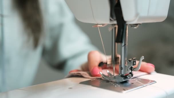 Woman sewing light fabric on a sewing machine close-up. - Felvétel, videó