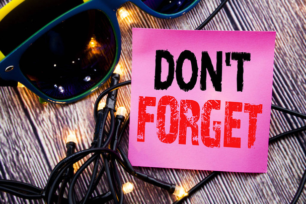 Hand writing text caption showing Do Not Forget. Business concept for Don t memory Remider written sticky note empty paper background with copy space with sunglasses - Photo, Image