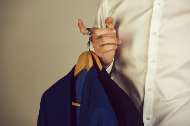 hanger with formal jacket in hand of man in shirt - Foto, Imagem