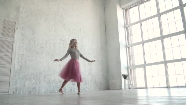 kecses fiatal balerina, klasszikus szoknyában és a háttérben a nagy ablakkal pointes tánc - Felvétel, videó