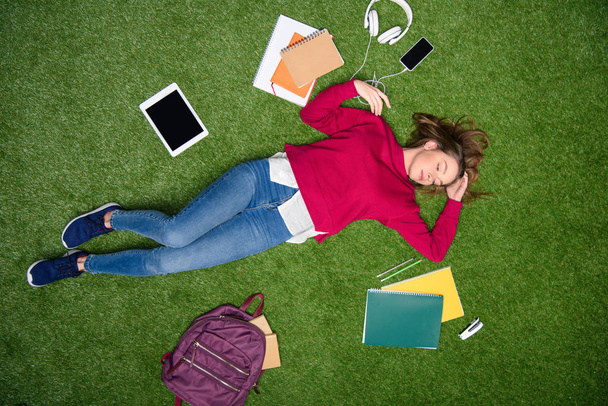 overhead view of young student sleeping on green lawn - Foto, imagen
