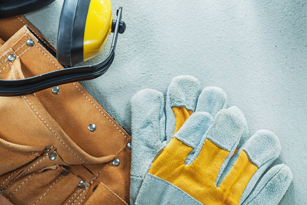 Leather construction belt protective gloves earmuffs on concrete - Foto, Imagen