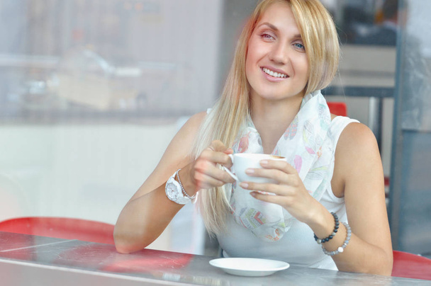 Женщина в модном кафе пьет кофе
 - Фото, изображение