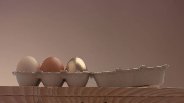 яєчна упаковка з 5 білими і одне золоте яйце
 - Фото, зображення