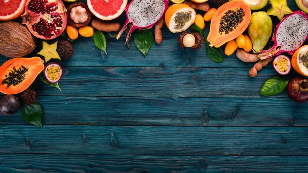 Tropical fruits, papaya, Dragon Fruit, rambutan, tamarind, cactus fruit, avocado, granadilla, carambola, kumquat, mango, mangosteen, passionfruit, coconut. On a wooden background. - Photo, Image