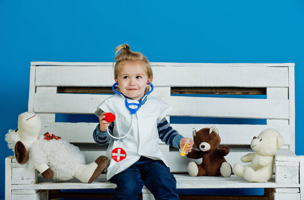 Happy child with toy pets sit on wooden bench - 写真・画像
