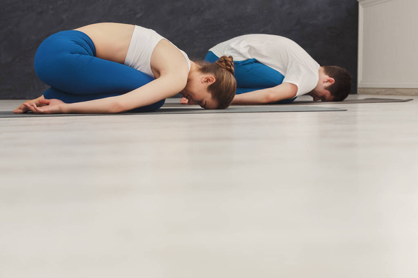 Pareja joven meditando juntos en el gimnasio
 - Foto, Imagen