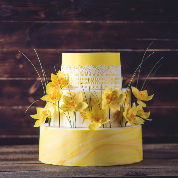 ウエディング 3 段ケーキ美しいホーム黄色赤春の花飾られています。デザートのコンセプト花の動向 - 写真・画像