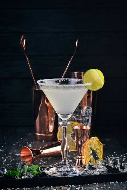Alcohol cocktail Margarita. Tequila, lime, ice. On the black background bar. - 写真・画像