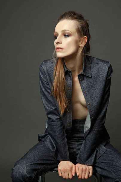 artistic portrait of a woman in a denim suit on a gray backgroun - Zdjęcie, obraz