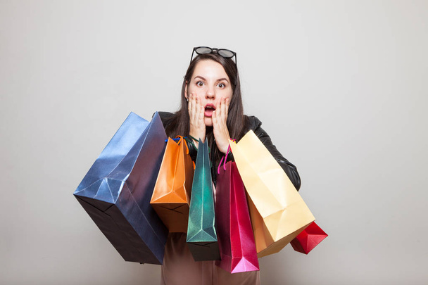 Shocked pretty girl holds shopping bags - Фото, зображення