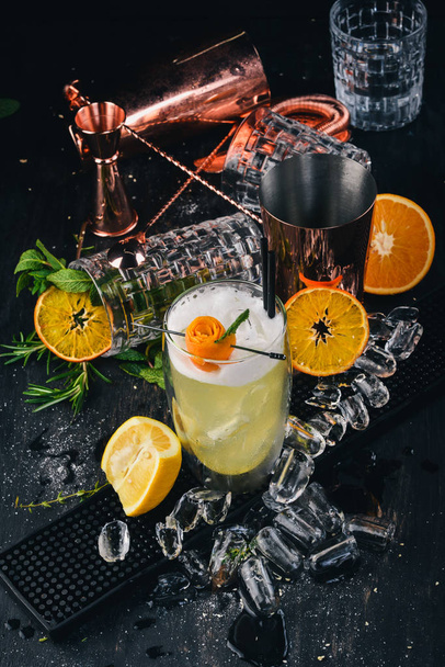 Alcohol cocktail Pinacolada. Orange, liquor, ice. On a black wooden background. - Foto, Imagen