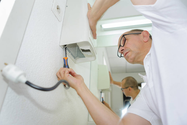 technician do cleaning investigate repairing air conditioner - Photo, Image