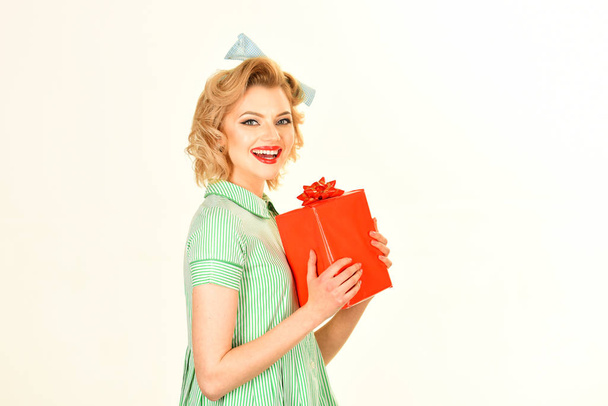 Amazed lovely young woman holding and giving present box - Foto, Bild
