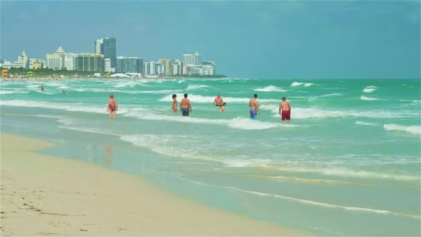 Miami Beach, Florida - February 22, 2018: Super high definition video of visitors enjoying the warm winter weather along the shoreline in popular South Beach on a windy day. - Footage, Video