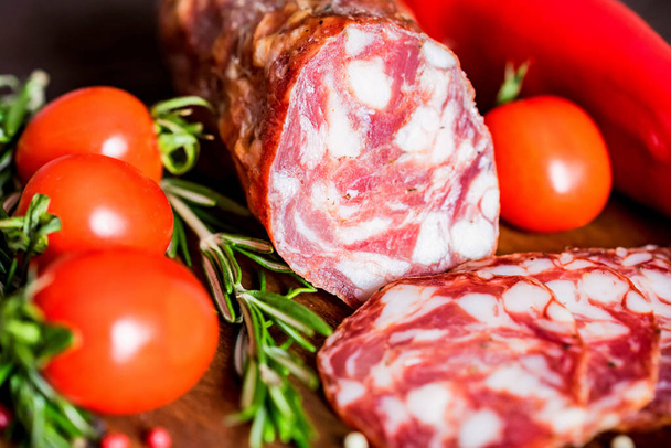 Tasty salami with tomatoes and peppercorn close - Photo, Image