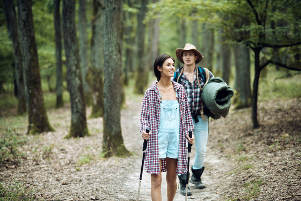 Couple in love hiking in forest with touristic equipment - Photo, image
