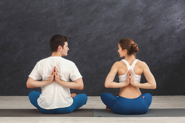 Молодая пара в классе йоги, растяжение спины
 - Фото, изображение