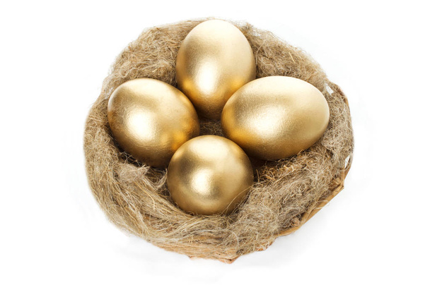 Nest with golden eggs on a white background - Foto, afbeelding