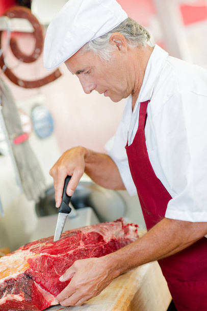Butcher cutting up meat - Fotoğraf, Görsel