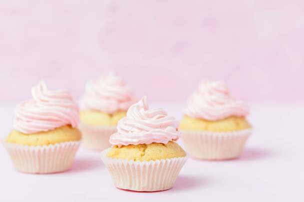 Cupcake decorado con crema de mantequilla rosa sobre fondo rosa pastel. Dulce pastel hermoso. Banner horizontal, tarjeta de felicitación para cumpleaños, boda, día de la mujer. Cierre la fotografía. Enfoque selectivo
 - Foto, Imagen