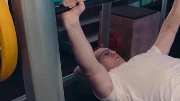Молодой спортсмен занимается на тренажере в спортзале
 - Кадры, видео