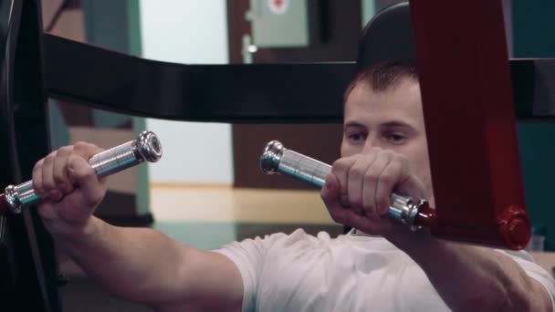 the young guy is engaged in an exercise room - Video, Çekim