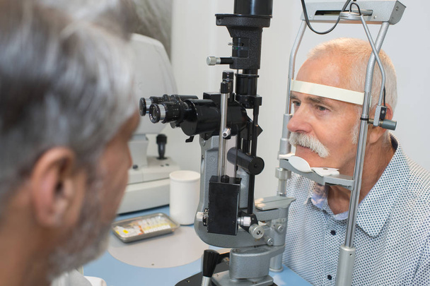 senior man checking his vision with ophtalmologist - Foto, Imagen