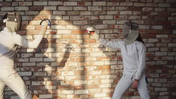 Мужчина и женщина фехтуют в тренировочном зале, бьют насильниками
 - Кадры, видео