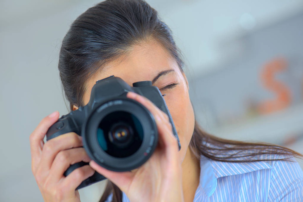 a girl taking a photo with a dslr camera - Fotó, kép