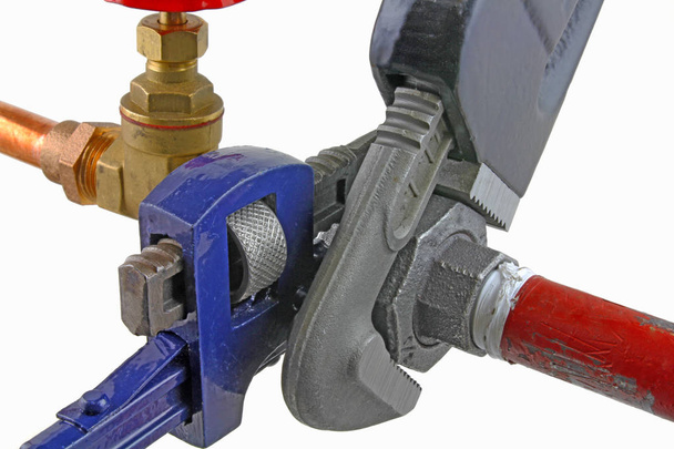 Clé de plombier serrant une vanne Une paire de clés réglables serrant un joint de compression isolé sur un fond blanc
 - Photo, image
