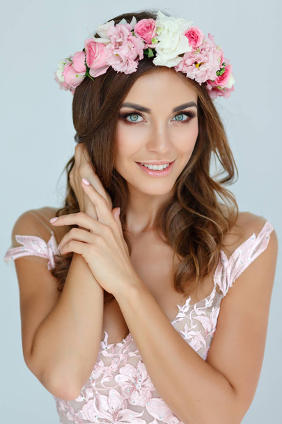 Portrait of a tender beautiful girl in a pink dress and a wreath - Foto, imagen