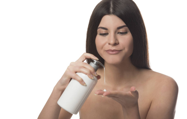 Beautiful brunette woman holding bottle with body lotion. Beauty concept. isolated on white background - 写真・画像