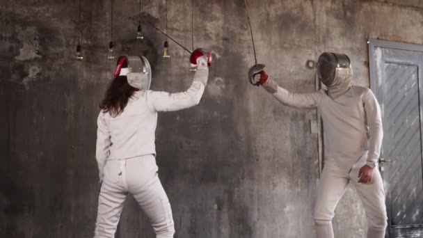 Esgrimistas estão treinando para executar chutes por espadas em uma sala de ginástica
 - Filmagem, Vídeo