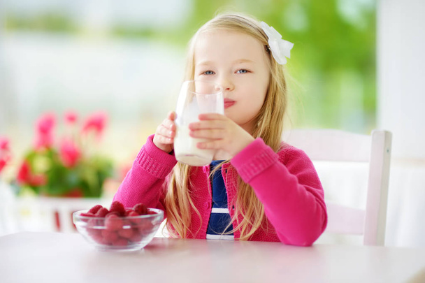 little girl drinking milk at home - Foto, imagen