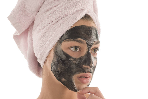Μαύρη μάσκα προσώπου. Όμορφη κοπέλα που συσσωρεύονται μακριά μαύρη μάσκα. Έννοια της ομορφιάς - Φωτογραφία, εικόνα