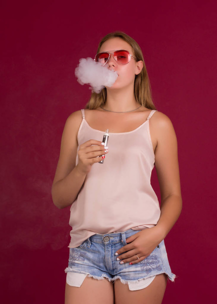 Young pretty girl with electronic cigarette - Foto, imagen