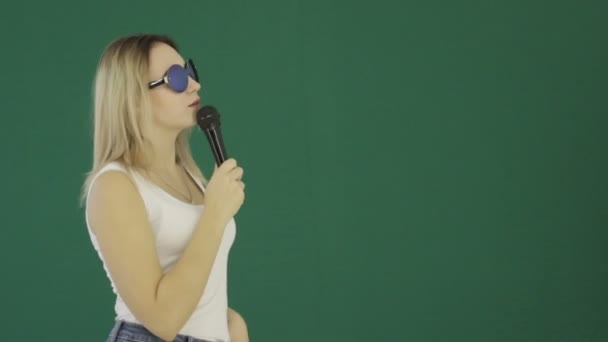 Young cute girl with microphone, isolated - Felvétel, videó